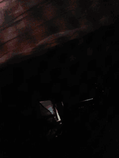 a dark room with a few lights visible in the corner
