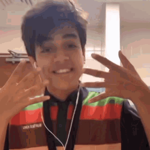 a young man wearing a burger king vest shows off his fingers