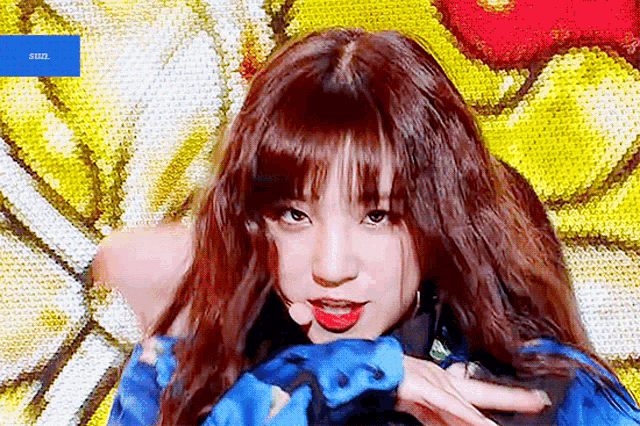 a girl with long hair is wearing a blue jacket and red lipstick
