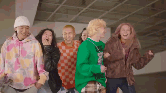 a group of people are dancing together and one of them has a green sweater on