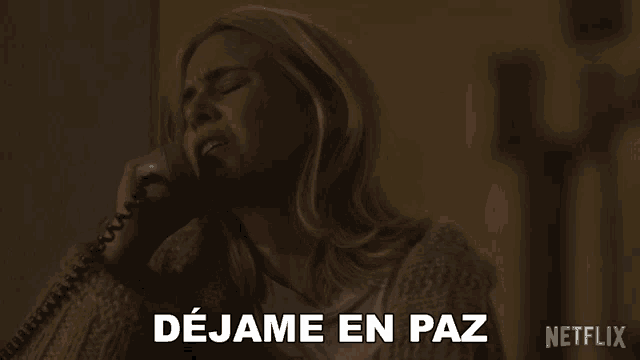 a woman talking on a phone with dejame en paz written on the bottom right
