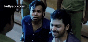 a group of men are standing next to each other and talking to each other in a room .