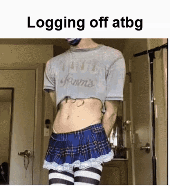 a man is wearing a crop top and a plaid skirt .