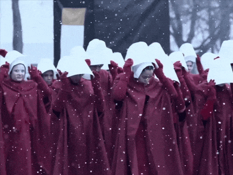 a group of people wearing red robes and white hats