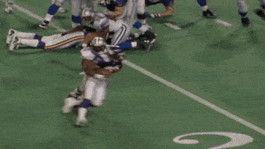 a football player with the number 50 on his jersey is being tackled by another player