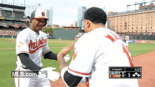 two baseball players shaking hands on a field with mlb.com in the corner