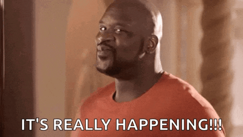 a bald man in an orange shirt is saying `` it 's really happening !!! ''