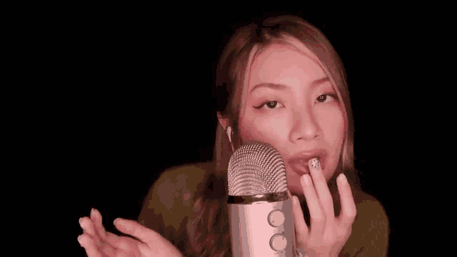 a woman is talking into a microphone with headphones on .