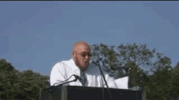 a bald man stands at a podium with the words du ska fa se pa ett ursvenskat barbari written above him