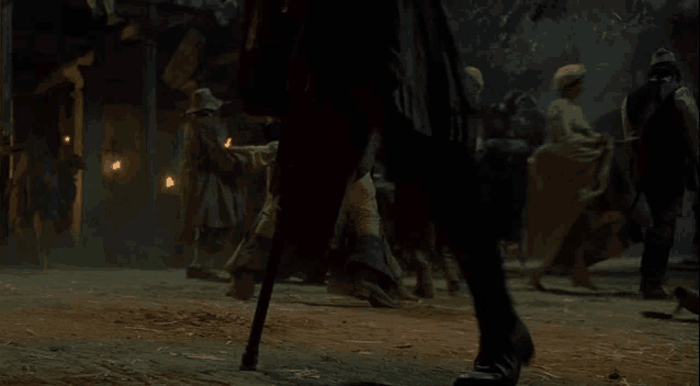 a man with a cane is walking in a crowd of people .