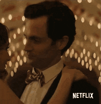 a man in a suit and bow tie is dancing with a woman .