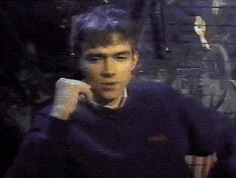 a man wearing a purple sweater is talking on a cell phone .