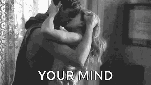 a man and woman are kissing in a black and white photo .