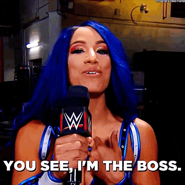 a woman with blue hair holds a microphone and says you see i 'm the boss