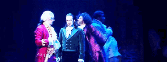 a group of men are standing on a stage in a theatre .