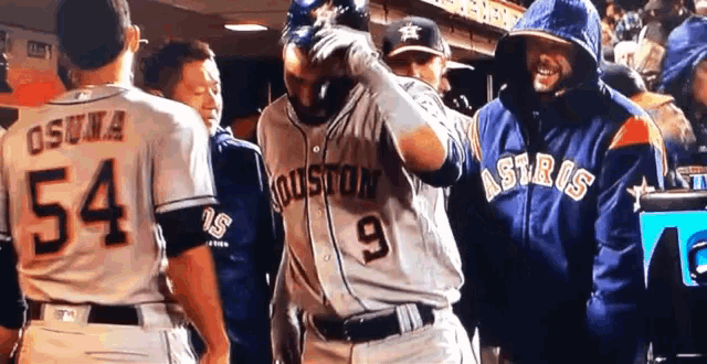 a man wearing a houston astros jersey stands next to a man wearing a 54 jersey