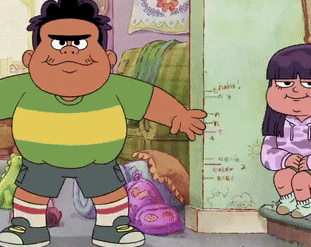 a boy and a girl are standing next to each other in front of a wall with measurements on it