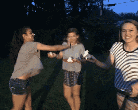 a group of young women are standing in a field holding ice cream cones