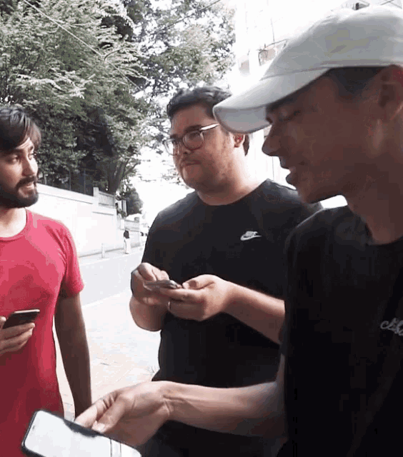 a man wearing a nike shirt is looking at a phone