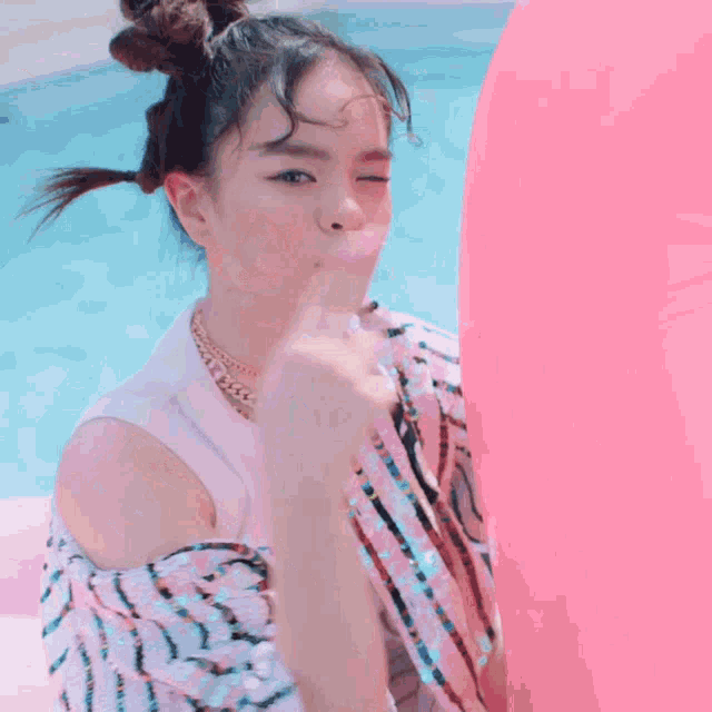 a girl with pigtails and a pink balloon smiles for the camera
