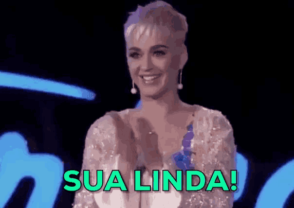 a woman in a white dress is smiling and applauding with the words sua linda behind her .
