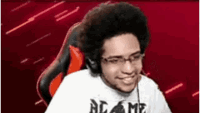 a man wearing glasses and headphones is sitting in a red chair .