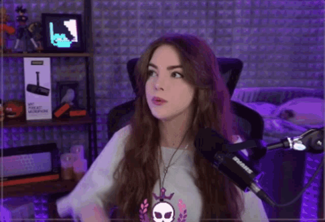 a woman with long hair is sitting in front of a shure microphone .