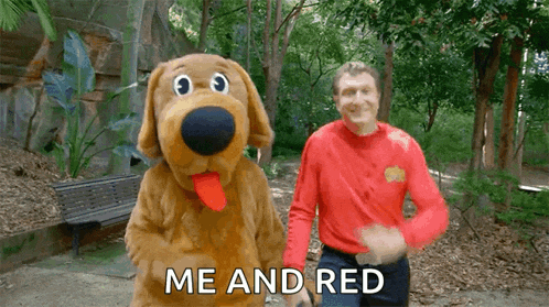 a man in a red shirt is standing next to a stuffed dog and the words me and red are visible