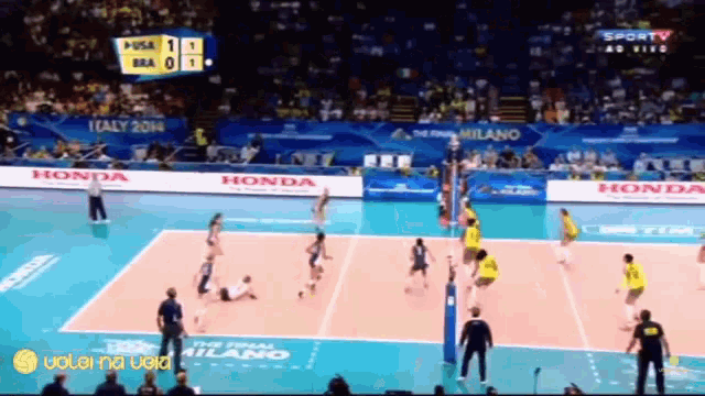 a volleyball game is being played on a court sponsored by honda and italy