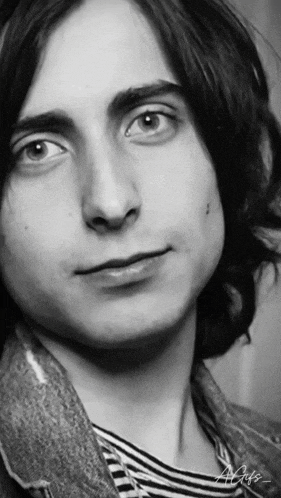 a close up of a young man 's face with the letters a and g on the bottom right