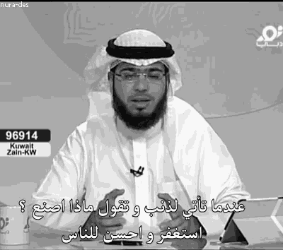 a black and white photo of a man with arabic writing on his shirt