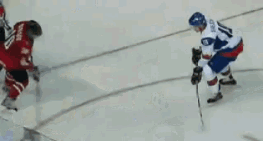 a hockey player with the number 25 on his jersey is trying to block a shot