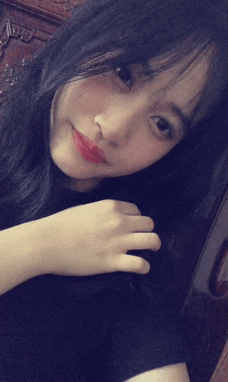 a girl with long black hair is taking a selfie with her hand on her hair