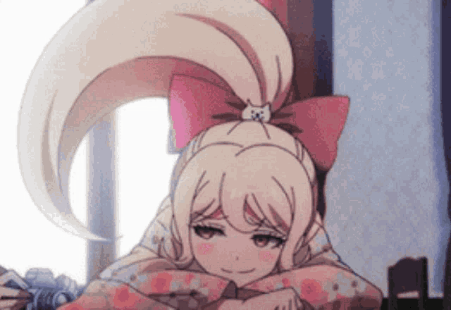 a girl with a pink bow on her head is laying on a bed .
