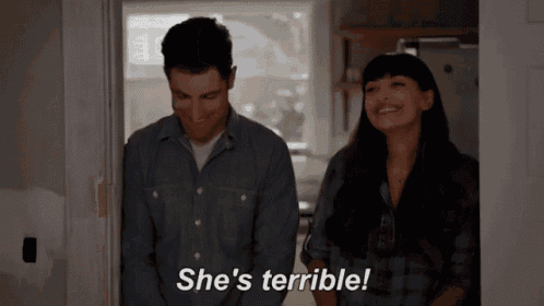 a man and a woman are standing in a doorway and the woman is saying she 's terrible