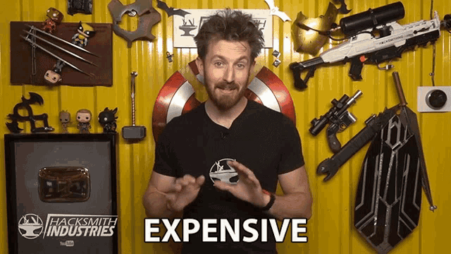 a man in a hacksmith industries shirt is talking about expensive weapons