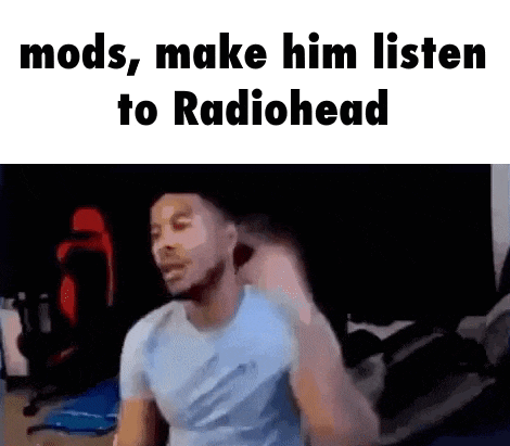 a man is sitting in front of a computer screen with the words `` mods , make him listen to radiohead '' written on it .