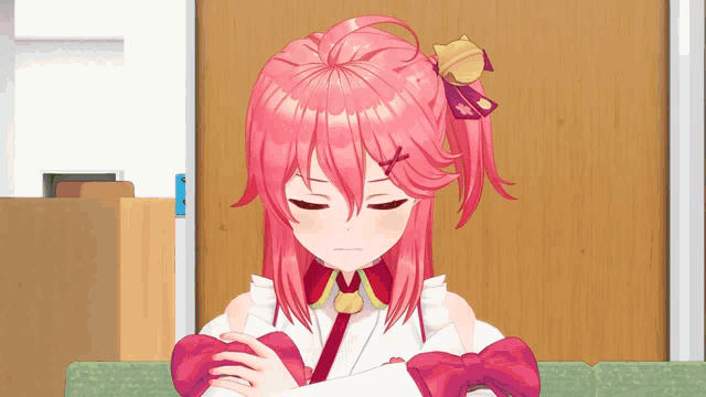 a girl with pink hair is sitting on a couch in front of a door
