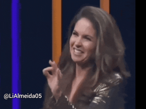 a woman is smiling while holding a microphone with the hashtag @ lialmeida05