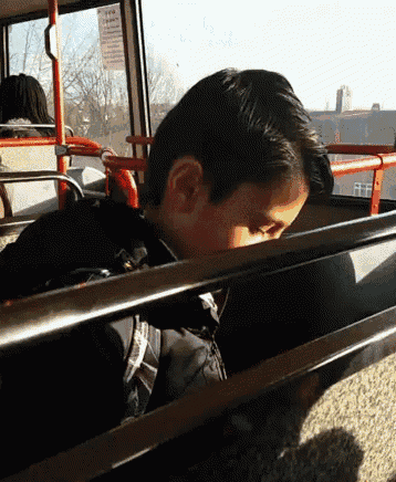 a young boy sitting on a bus with a sign that says no smoking