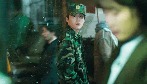 a man in a military uniform has a yellow emblem on his hat