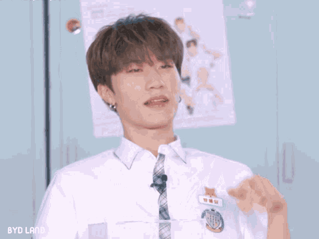 a boy in a white shirt and tie is making a heart with his hand