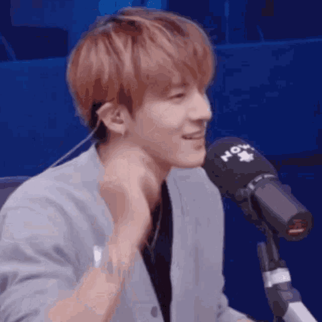 a man with red hair is sitting in front of a microphone .