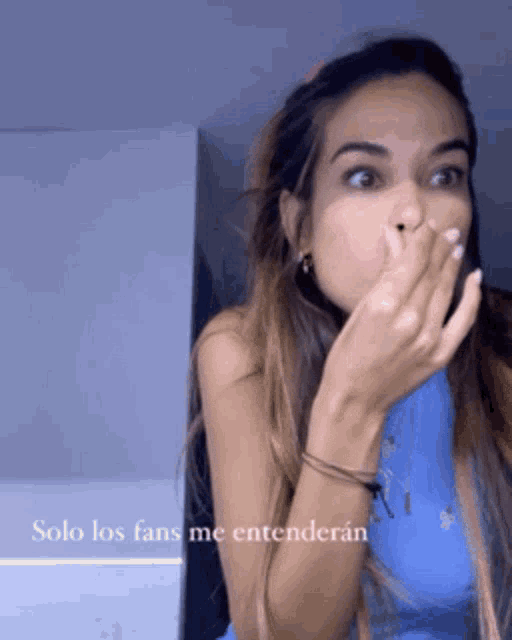 a woman is covering her mouth with her hand and the words solo los fans me entenderan are below her