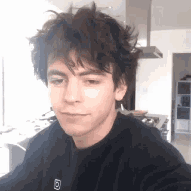 a young man is taking a selfie in a kitchen .