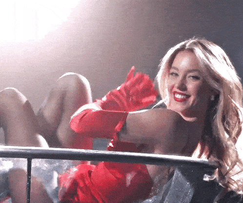 a woman wearing red gloves and a black top smiles