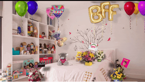 a bedroom with balloons and flowers and a teddy bear that says chelsea on it