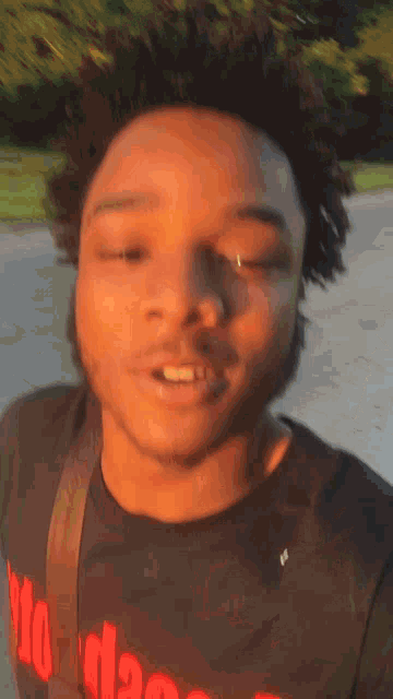 a young man wearing a black shirt with red letters that says ' miami ' on it