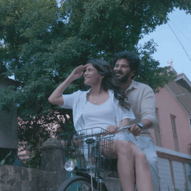 a man is riding a bike with a woman sitting on the back