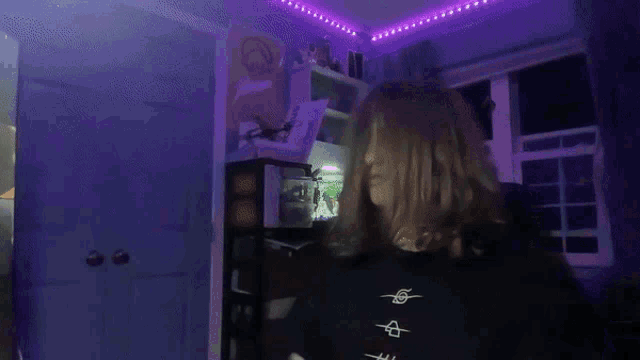 a person sitting in a chair with purple lights on the ceiling